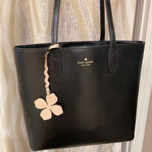 Black Kate Spade satchel with flower purse charm